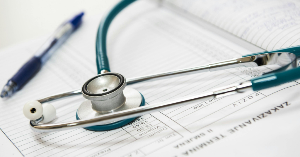 A stethoscope rests on an open medical chart with a pen nearby, symbolizing healthcare, diagnosis, and medical documentation.