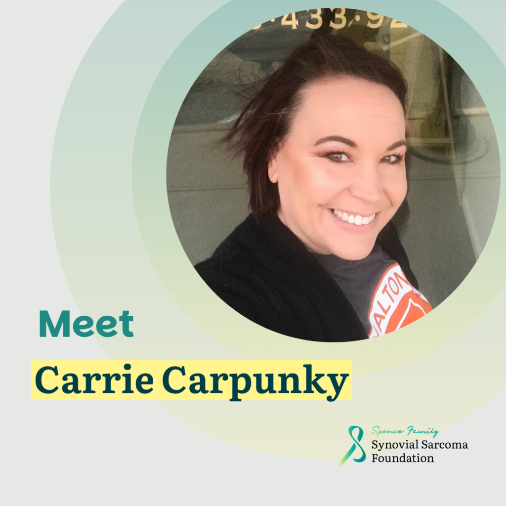 A woman with short brown hair smiles at the camera. Text reads: "Meet Carrie Carpunky." Includes Synovial Sarcoma Foundation logo and a teal ribbon in the bottom right corner.