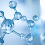 A close-up of a shiny, silver molecular model with connected spheres representing atoms, set against a blurred blue and white laboratory background.