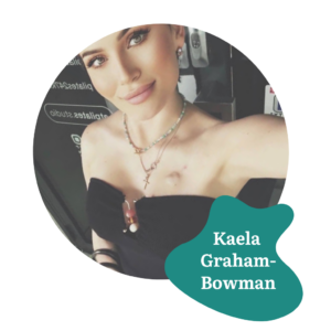 Woman with light eyes and a slight smile poses for a selfie wearing layered necklaces and a black top. A teal shape with the text “Kaela Graham-Bowman” is on the bottom right.